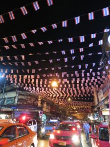 taxis dropping off in Khao San Road area with Thai flags